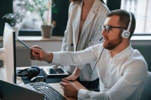 Analyzing information that is on the screen. Two IT professionals are working together in the modern office.